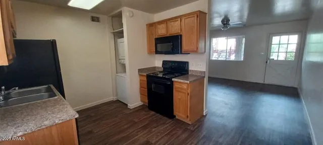 a kitchen with granite countertop white cabinets and black appliances