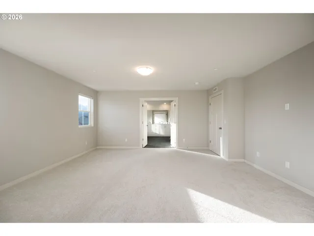 a view of an empty room with window and closet area
