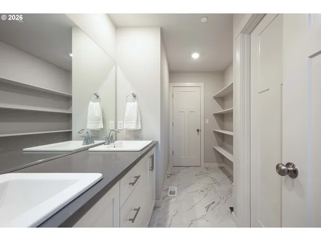 a bathroom with a double vanity sink a mirror and a shower