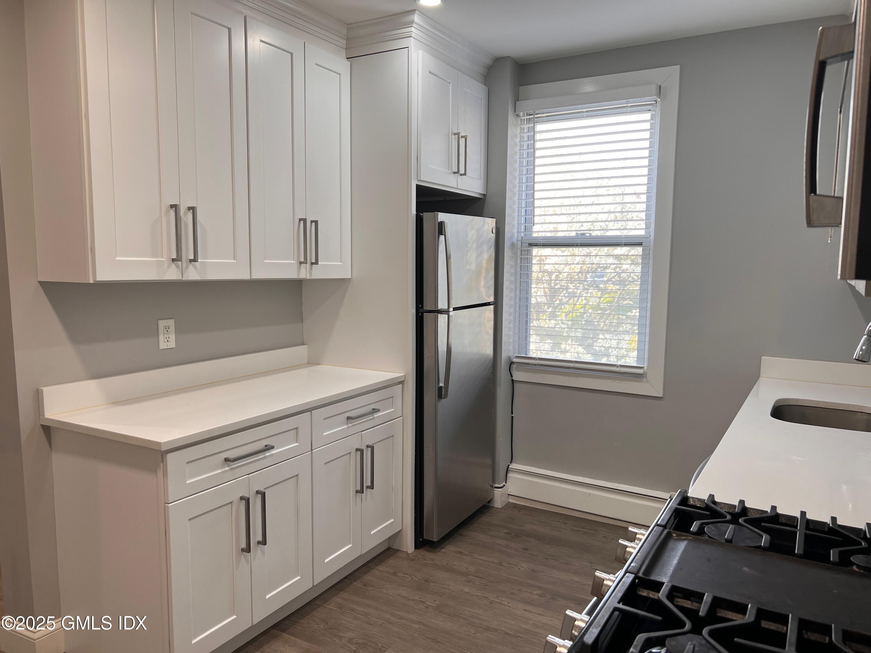 15 Beech Street, Unit 2N Greenwich, CT 06830 - Photo 2 of 15 a kitchen with white cabinets and white appliances