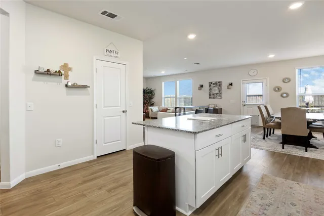 a kitchen with a sink cabinets and wooden floor