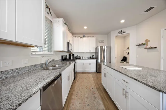a large kitchen with granite countertop lots of counter space and window