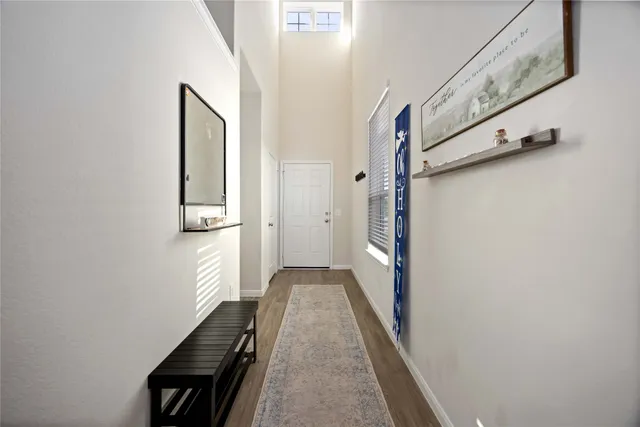 a view of a hallway with wooden floor and staircase