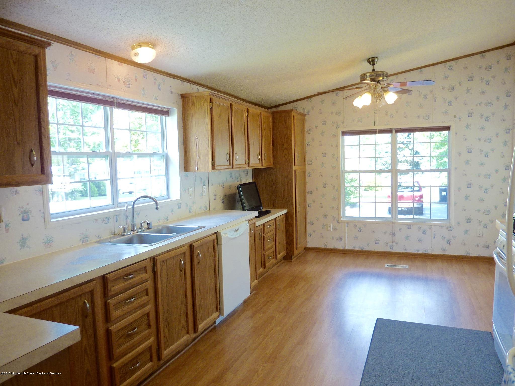 58 Village Road Morganville, NJ 07751 - Photo 6 of 8 a kitchen with sink cabinets and wooden floor