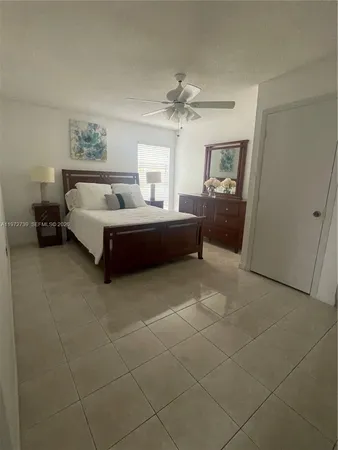 a spacious bedroom with a bed and a chandelier