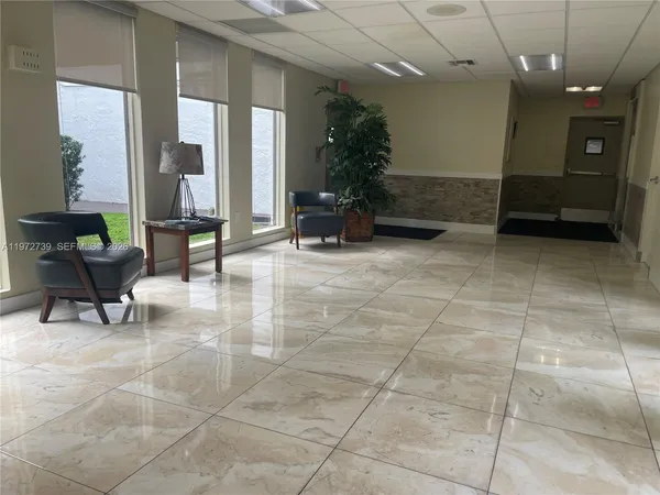 a lobby with furniture and a potted plant