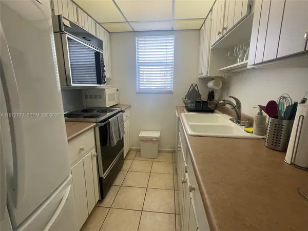 a kitchen with a sink a stove and cabinets