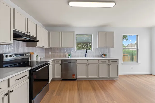 a kitchen with stainless steel appliances granite countertop a sink and stove top oven