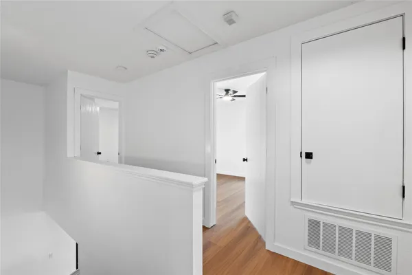 a view of a hallway with wooden floor
