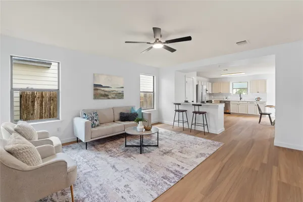 a living room with furniture and a wooden floor