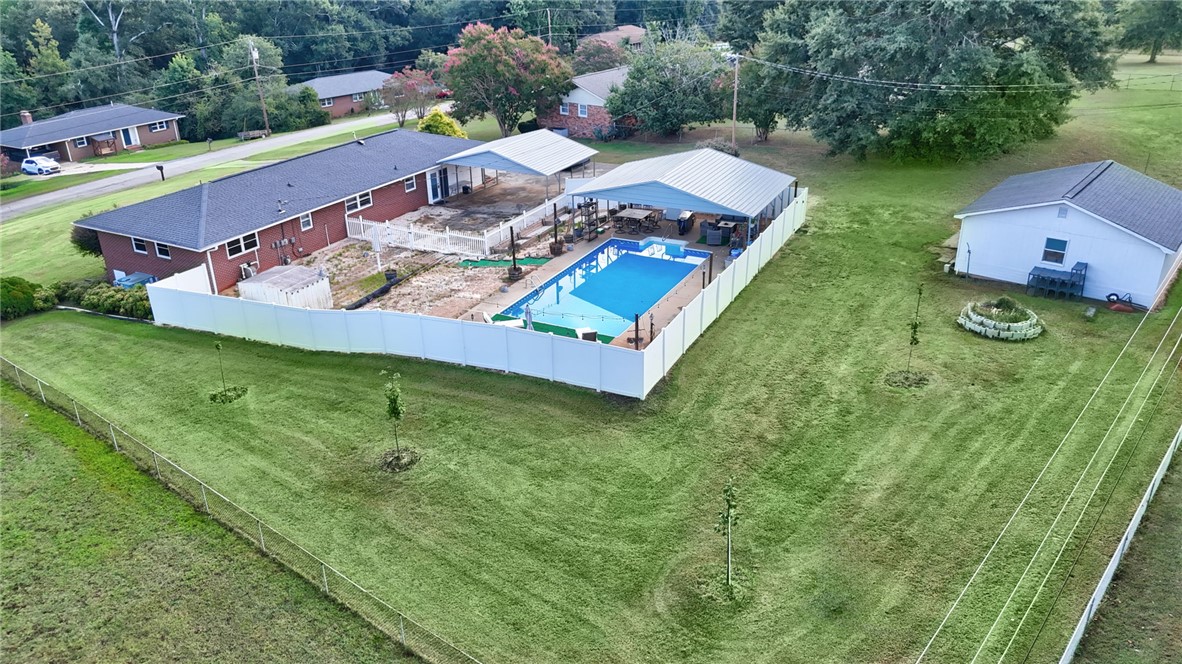 121 Wilson Road Anderson, SC 29625 - Photo 39 of 40 A spacious grassy lawn surrounds the fenced swimming pool and detached structures.