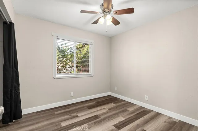 a view of a hallway with wooden floor and a bathroom