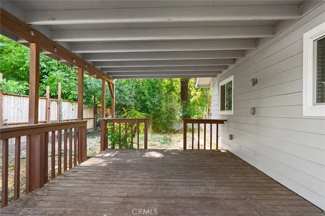 a view of a deck with a large tree and wooden fence