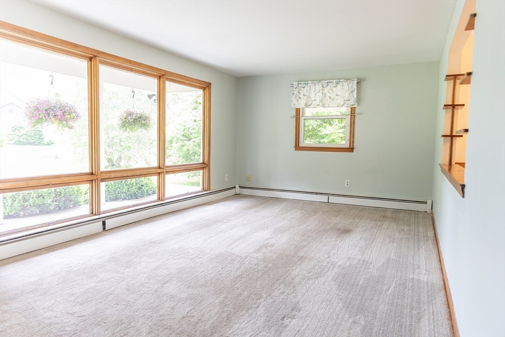 59 Mountain Road Holyoke, MA 01040 - Photo 8 of 40 a view of an empty room with a window and wooden floor