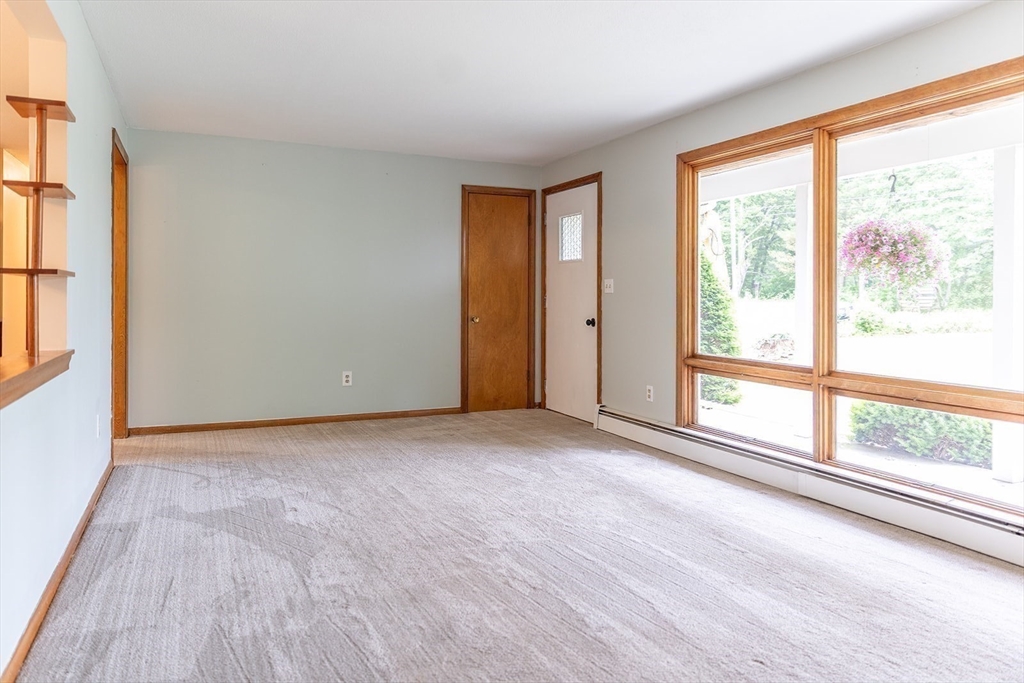 59 Mountain Road Holyoke, MA 01040 - Photo 10 of 40 a view of an empty room with a window and wooden floor