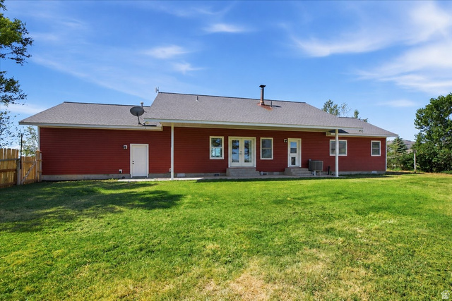 1634 West Arimo Road Arimo, ID 83214 - Photo 25 of 89 Spacious backyard featuring a manicured lawn, a red siding exterior, and a white fence