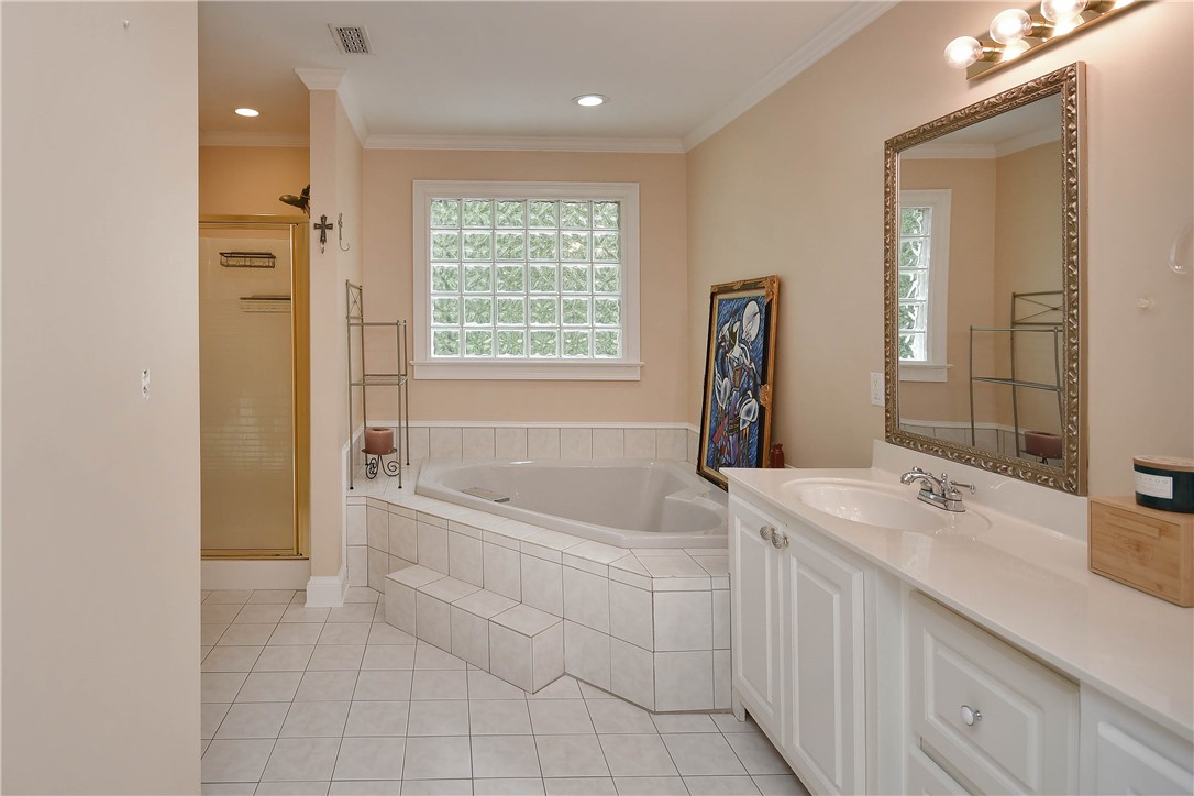 197 Deer Creek Road Easley, SC 29640 - Photo 22 of 50 Step into a well-lit bathroom featuring a spacious corner tub and a functional glass block window.