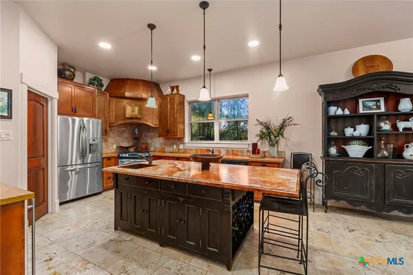 a kitchen with stainless steel appliances granite countertop a sink a stove and a refrigerator