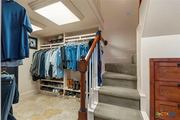 a view of walk in closet with clothes and shoes
