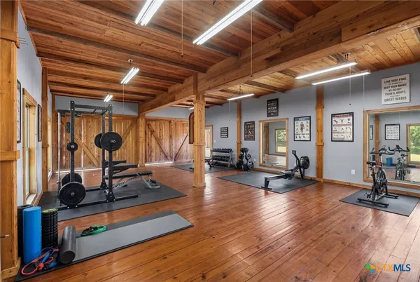 a living room with furniture gym equipment and a large window