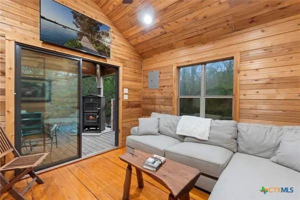 a view of a wooden house with a large tree