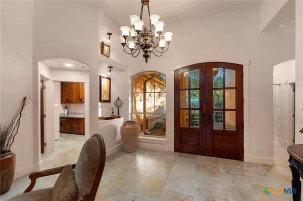 a view of a livingroom with furniture chandelier and wooden floor