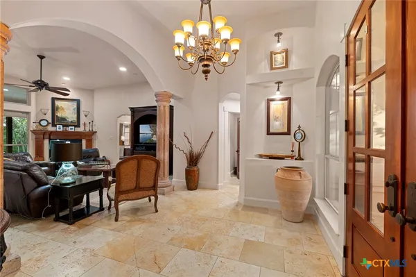 a living room with patio furniture and a chandelier