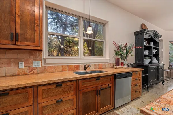 a kitchen with stainless steel appliances granite countertop a sink and a window