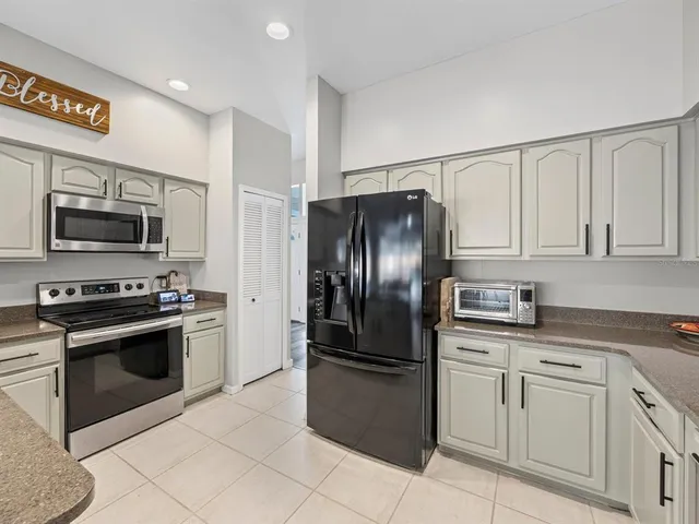 a kitchen with stainless steel appliances granite countertop a refrigerator stove and sink