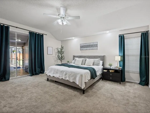 a spacious bedroom with a bed a dresser and a chandelier
