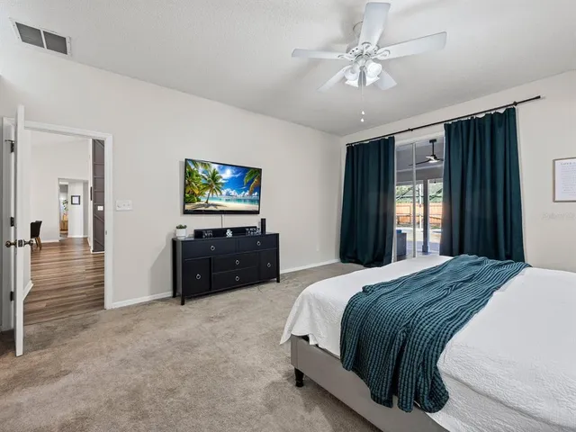 a spacious bedroom with a bed and a chandelier