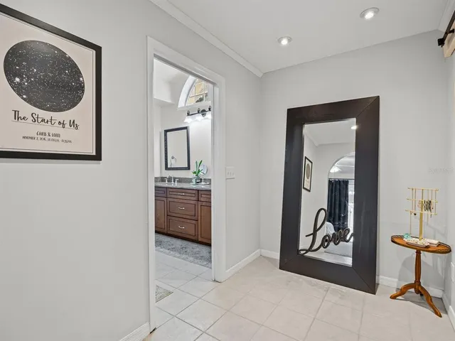 a view of a hallway to a livingroom and a kitchen with furniture