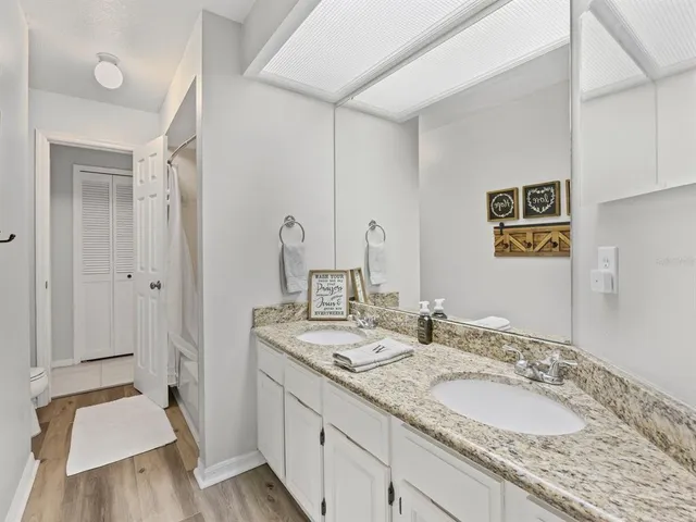 a bathroom with a granite countertop double vanity sink and a mirror