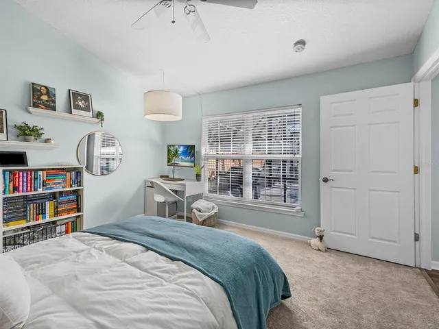 a spacious bedroom with a bed a dresser and a book shelf
