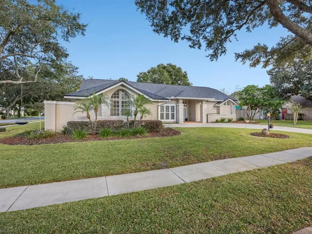 a view of a house next to a yard with big trees