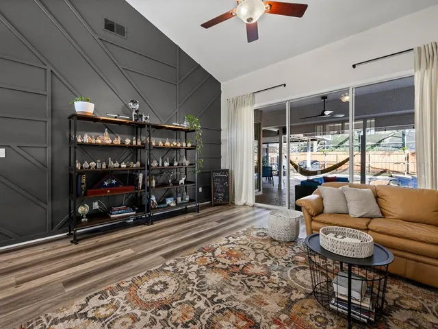 a living room with furniture a chandelier and a floor to ceiling window