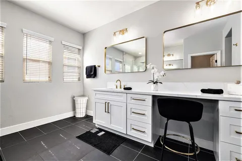 a spacious bathroom with a double vanity sink a mirror a and a window