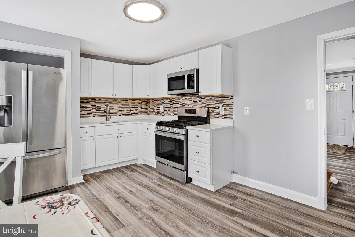 4004 Dudley Avenue Baltimore, MD 21213 - Photo 2 of 36 a kitchen with stainless steel appliances granite countertop a stove a sink and a refrigerator