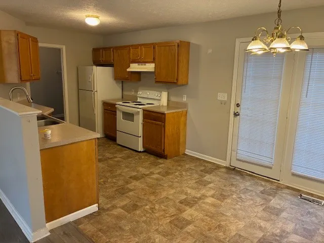 a kitchen with a refrigerator sink and stove top oven