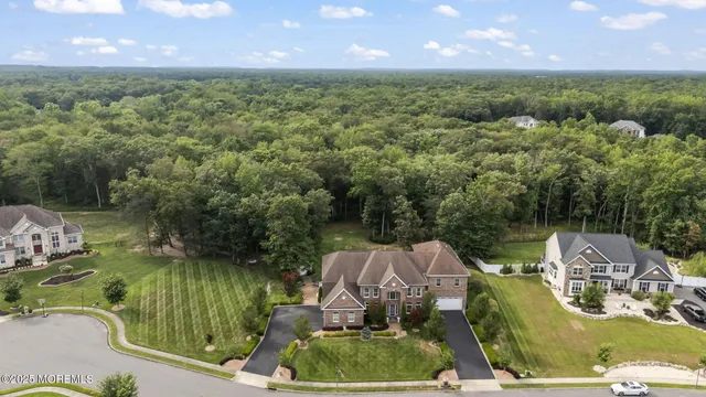 an aerial view of a house with a garden and lake view