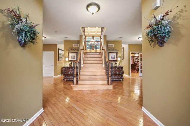 a bedroom with a bed a couch and a window with wooden floor
