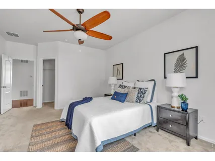 a bedroom with a bed and a ceiling fan