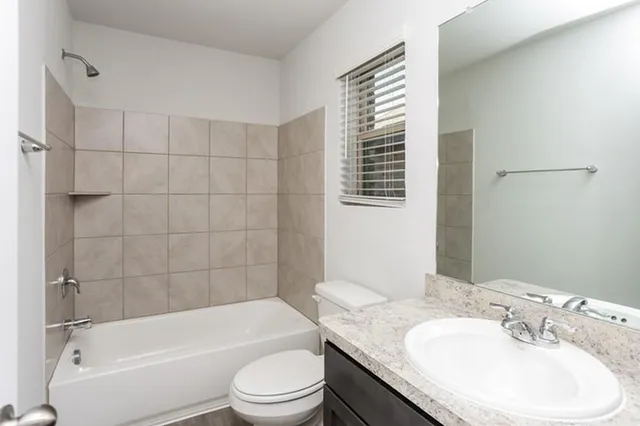 a bathroom with a granite countertop sink toilet and bathtub