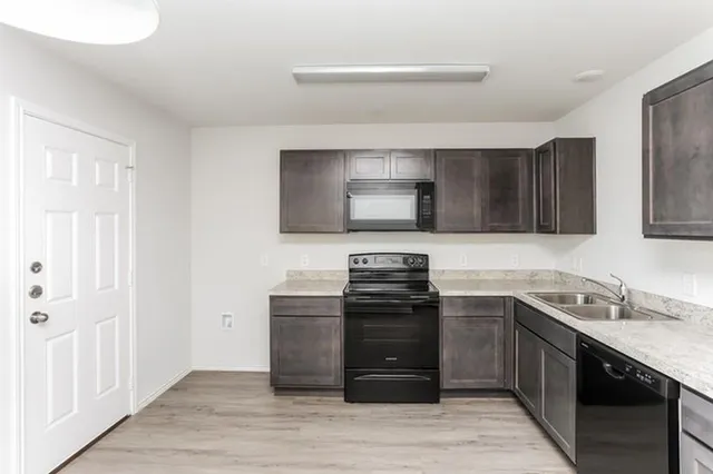 a kitchen with stainless steel appliances granite countertop a sink stove and microwave