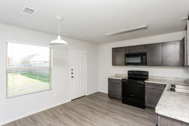a kitchen with a sink a microwave and cabinets
