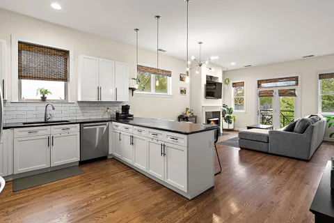 a large kitchen with granite countertop a large center island a sink a window and stainless steel appliances