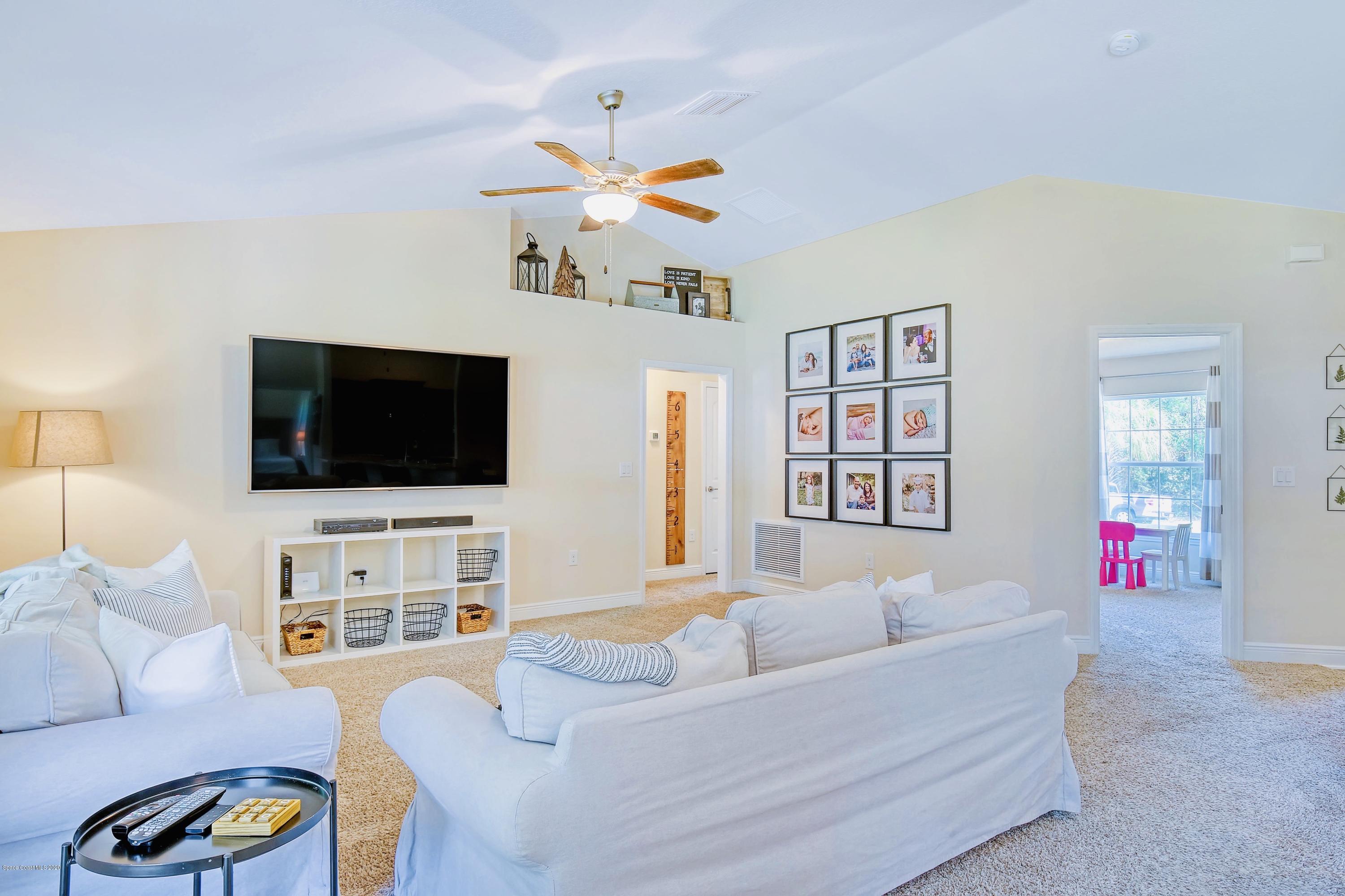 919 Thompson Road Southwest Palm Bay, FL 32908 - Photo 11 of 38 a living room with furniture and a flat screen tv