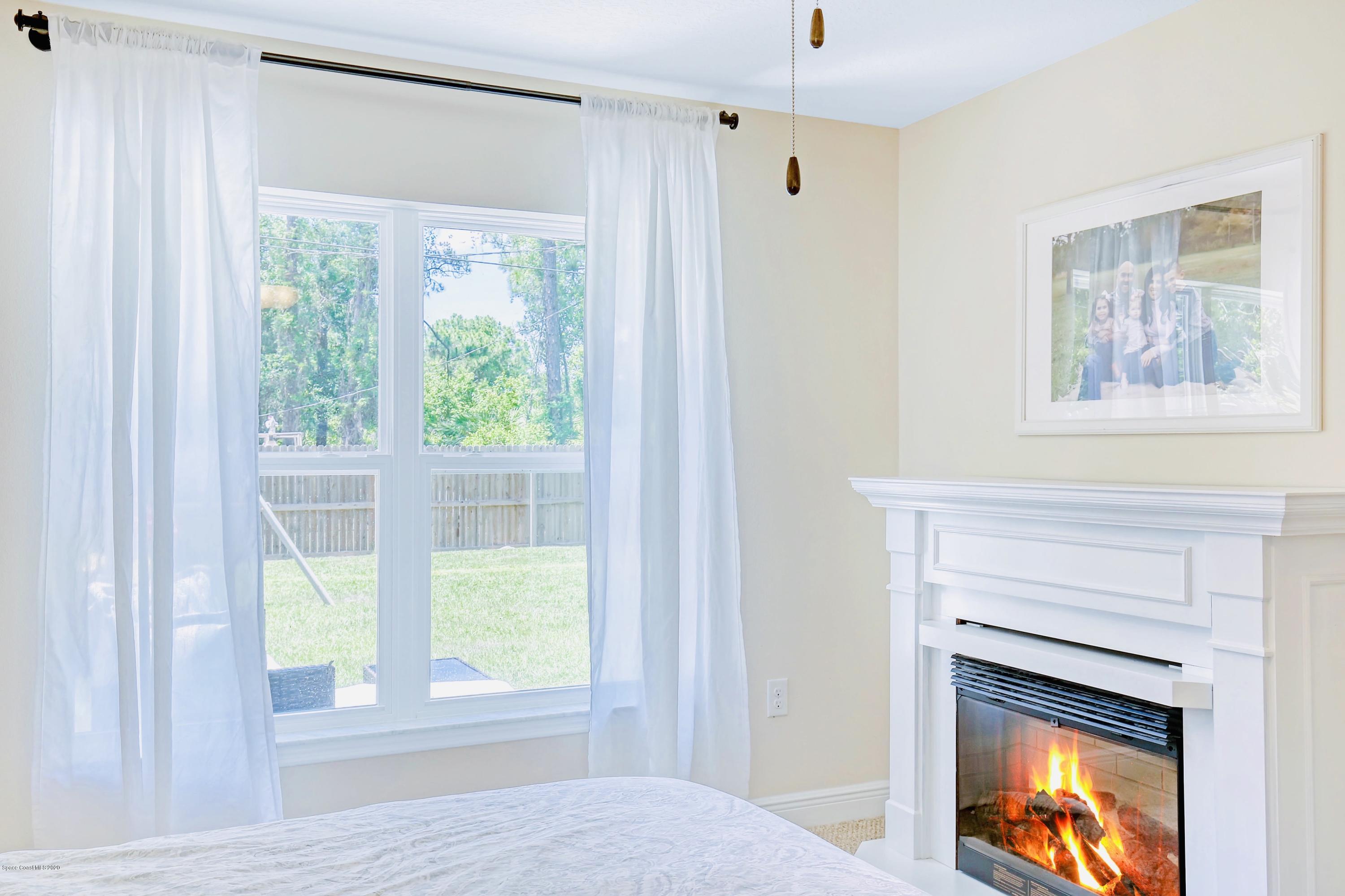 919 Thompson Road Southwest Palm Bay, FL 32908 - Photo 17 of 38 a view of an empty room with a fireplace and a window