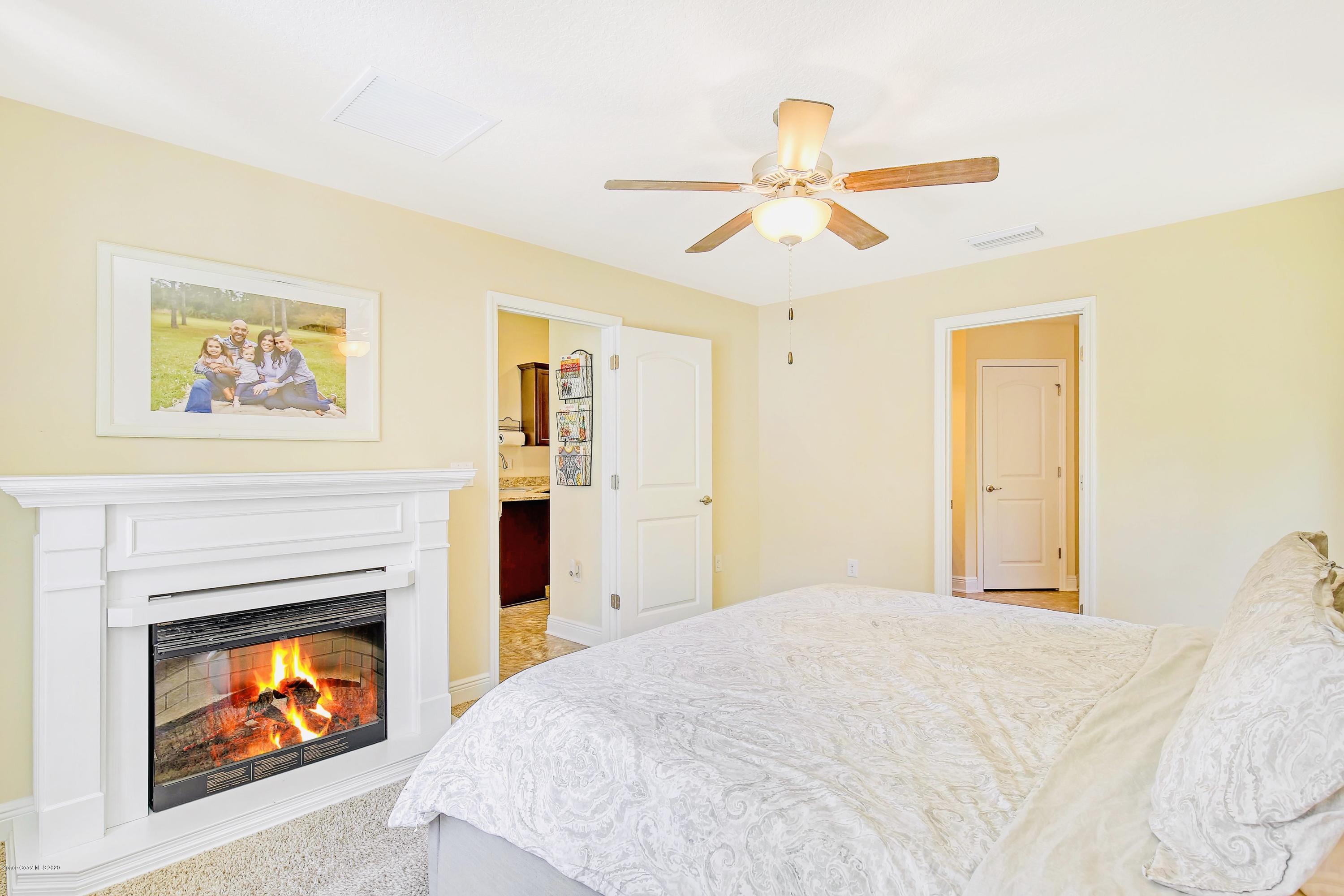 919 Thompson Road Southwest Palm Bay, FL 32908 - Photo 18 of 38 a bedroom with a bed and a fireplace