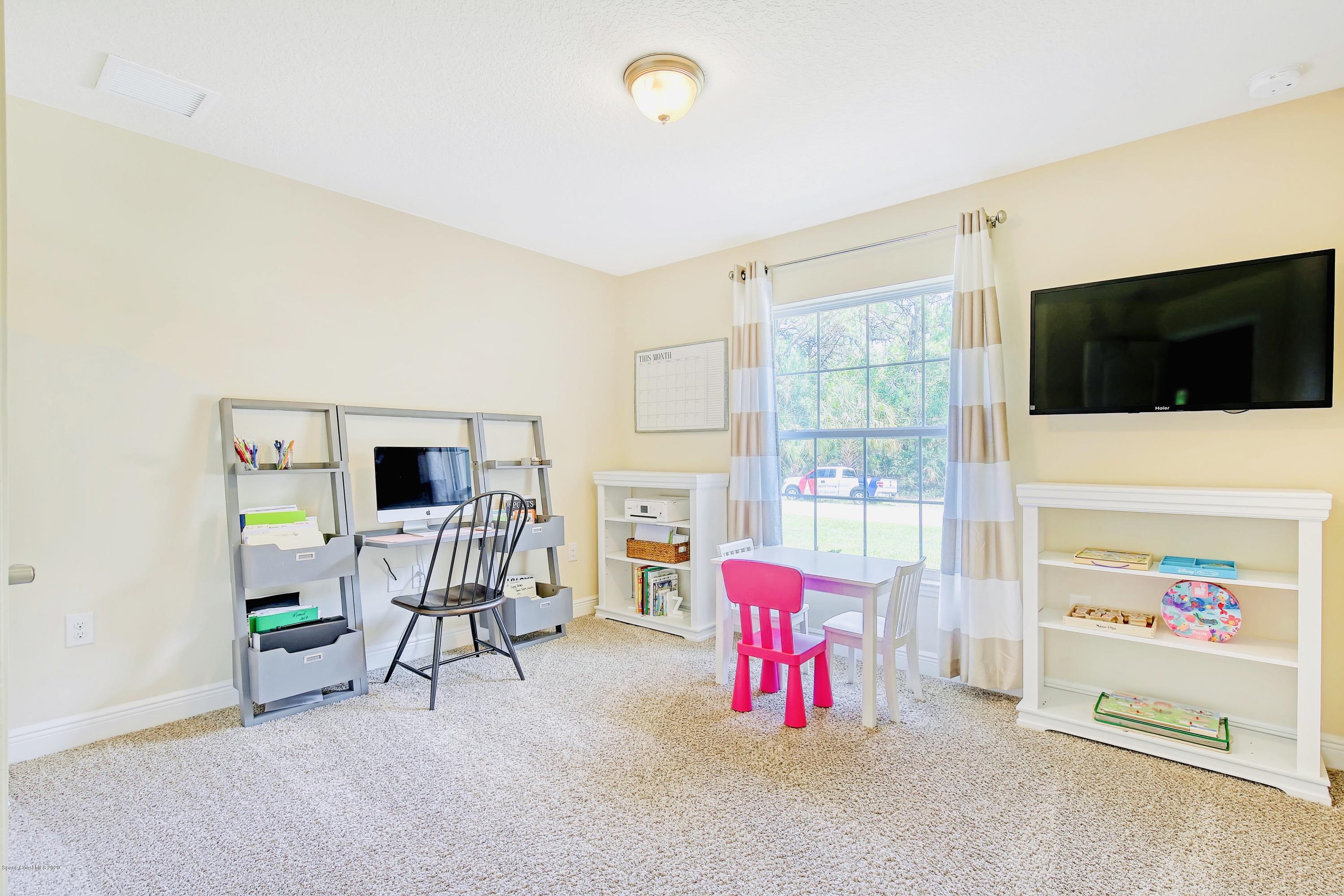 919 Thompson Road Southwest Palm Bay, FL 32908 - Photo 22 of 38 a living room with furniture and a flat screen tv